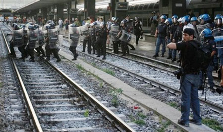 Police chase protesters across a rail track at the Termini train station during a demonstration in Rome, Tuesday, July 7, 2009, on the eve of the G8 (Group of Eight) summit scheduled from July 8 to July 10 in L'Aquila, central Italy, the medieval town hit by a major earthquake April 6.